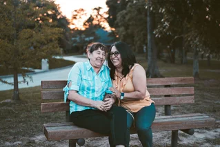 mother and daughter sitting on bench